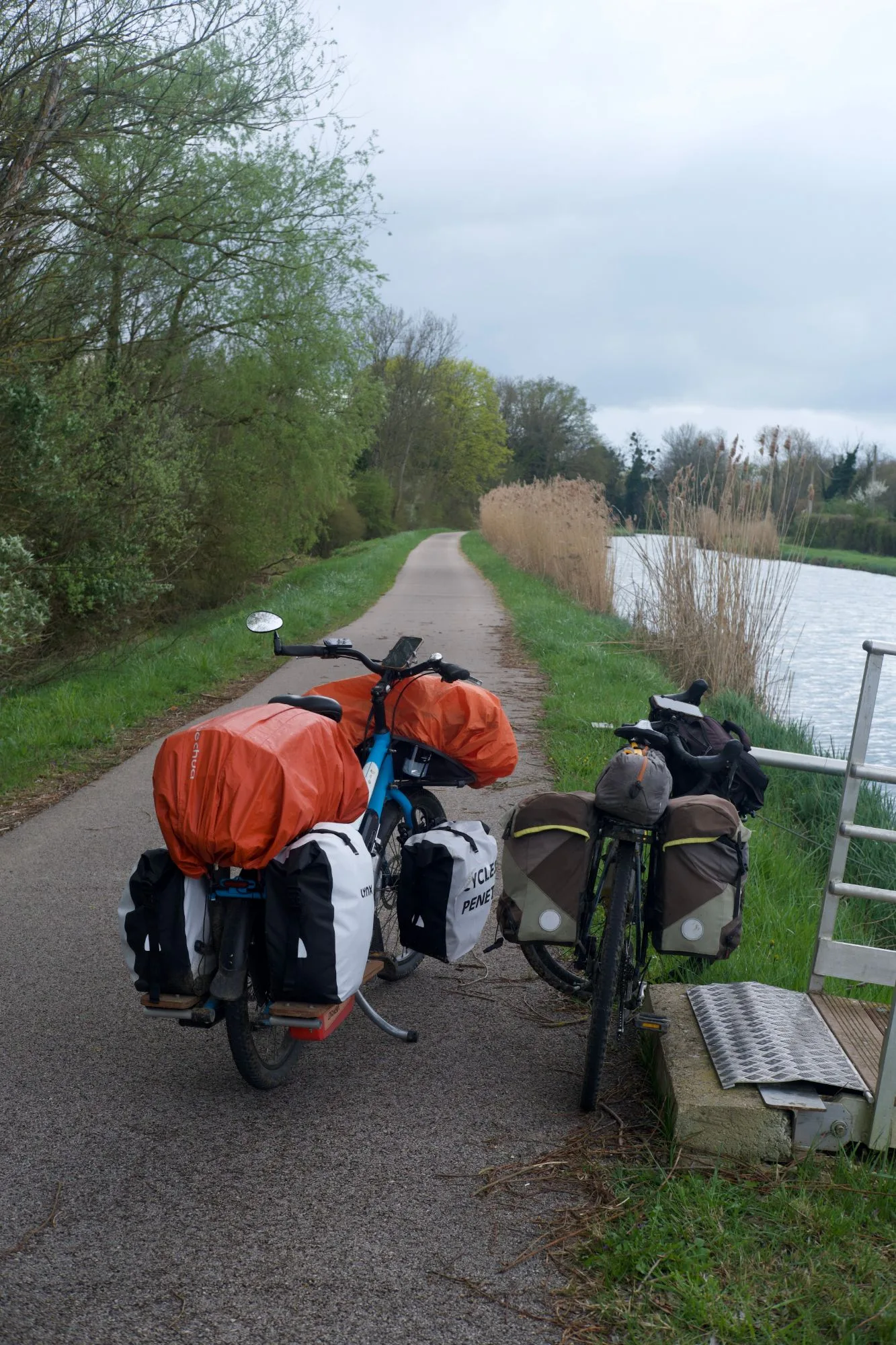 Deux vélos chargés de sacoches à l’arrêt sur la piste, au bord de la Saône